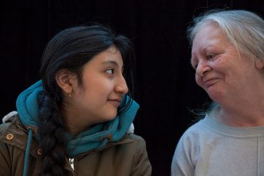 Older woman and young girl gaze at each other