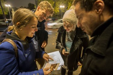 People huddle to look at map on Southbank walking dinner
