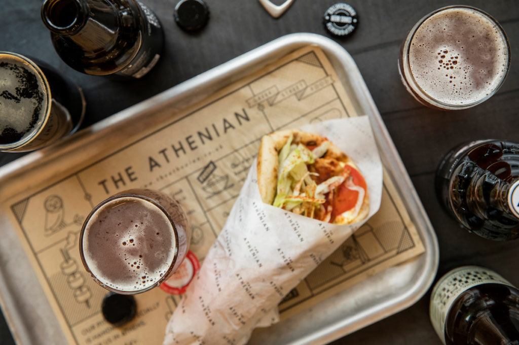 A halloumi wrap and glass of beer on a tray at The Athenian